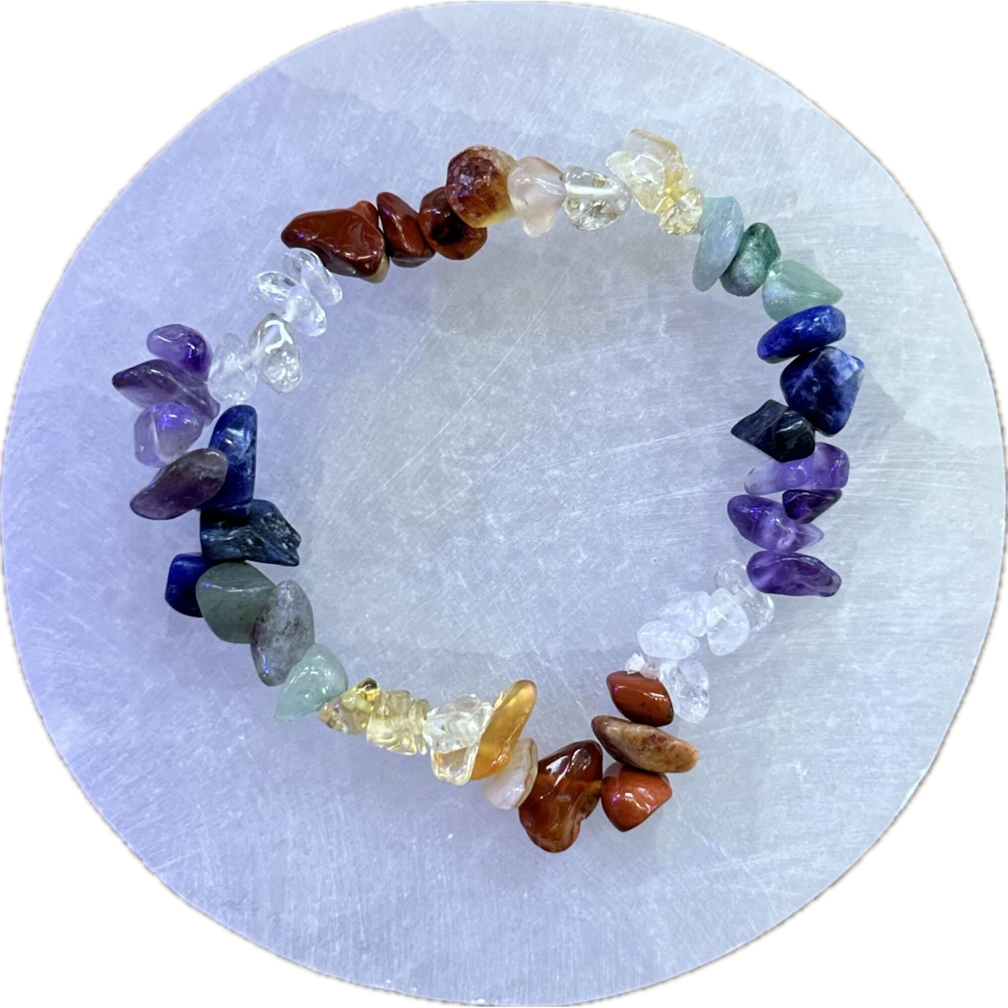 This is a picture of a metaphysical bracelet, containing a variety of minerals. Displayed on a selenite disk.